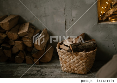 Cozy Firewood Basket and Stack in Rustic Interior 133484414