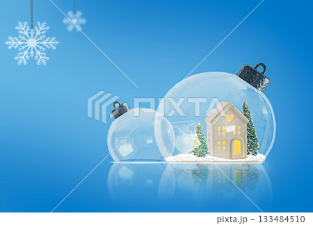Two glass Christmas tree ornaments with miniature houses and trees inside. Two glass Christmas tree ornaments with miniature houses and trees inside. 133484510