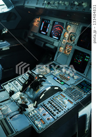 Control panel of a commercial airplane cockpit featuring various instruments and displays in a modern aircraft during daytime preparations 133484831