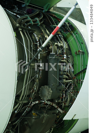 Detailed view of an aircraft engine showing intricate machinery and components during maintenance at an airport hangar 133484849