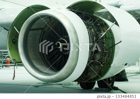 Close view of jet engine showing intricate design and engineering details in aircraft maintenance hangar during daytime 133484851