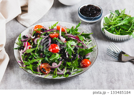 A delicious salad of beans, tomatoes, herbs and onions on a plate on the table A delicious salad of beans, tomatoes, herbs and onions on a plate on the table 133485184
