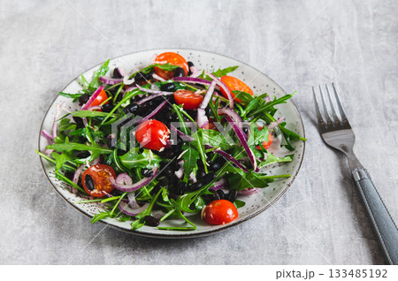 Close-up of vegetarian salad with vegetables and herbs on a plate on the table 133485192