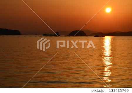 夕日が海を照らす静かなシルエット風景 夕日が海を照らす静かなシルエット風景 133485769