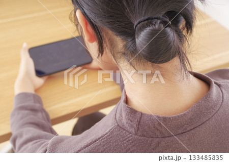 自宅でスマートフォンを使う女性 自宅でスマートフォンを使う女性 133485835