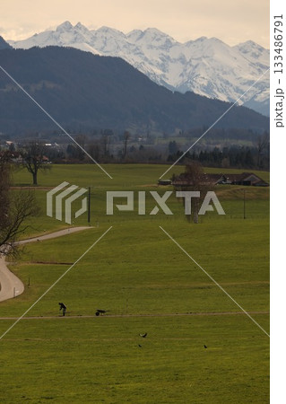 A man is riding a skateboard on a road in front of a mountain 133486791