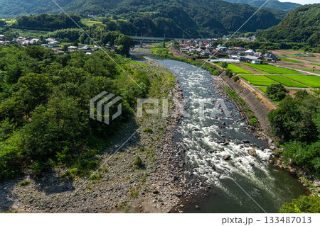 群馬県利根川の夏の清流と急流、河原と集落の風景 133487013