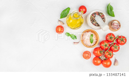 Fresh cooking ingredients with tomatoes, basil, garlic, olive oil and spices on white background, top view, copy space Fresh cooking ingredients with tomatoes, basil, garlic, olive oil and spices on white background, top view, copy space 133487141