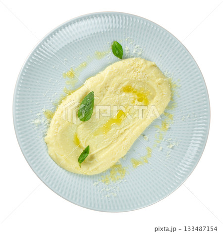 Creamy mashed potatoes with parmesan and basil leaves on a light plate, top view, isolated on white 133487154