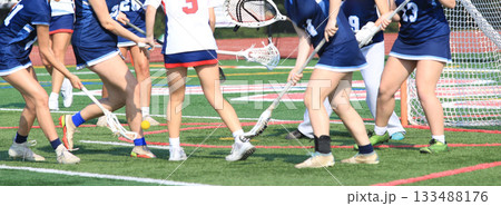 Girls Playing Lacrosse fFghting for the Ball in front of the Goal 133488176