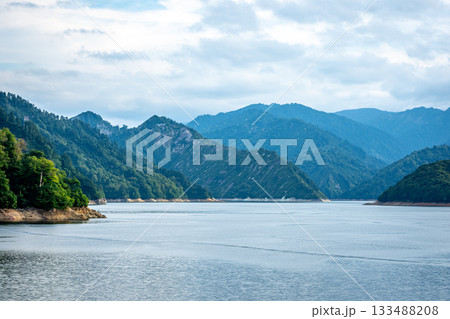 新潟県奥只見湖の雄大な山並みと水面、夏の終わりの曇り空 新潟県奥只見湖の雄大な山並みと水面、夏の終わりの曇り空 133488208