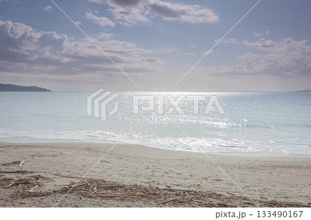南房総市の海辺、太陽の光が反射する水面と広がる砂浜 南房総市の海辺、太陽の光が反射する水面と広がる砂浜 133490167
