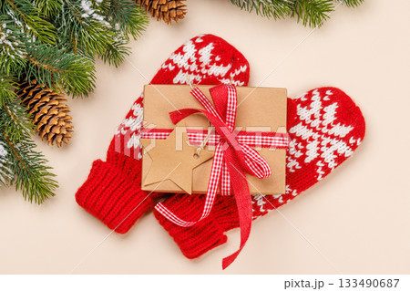 Gift box on winter mittens and beige background 133490687