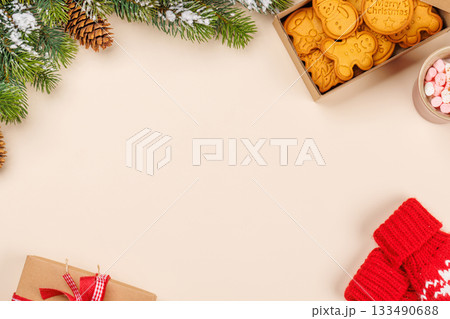Gingerbread cookies, cup with marshmallows and snowy fir branches 133490688