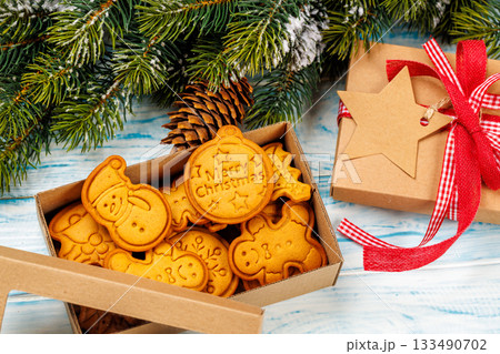 Gingerbread cookies, gift box and snowy fir branches 133490702