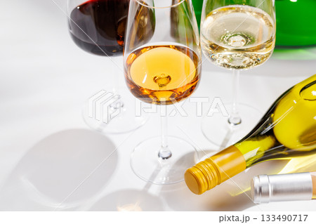Different wine bottles and glasses on white background 133490717