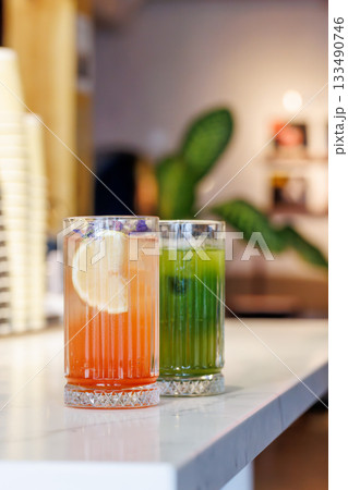 Assorted summer lemonades in glass jars with fresh fruits, ice, and garnishes 133490746