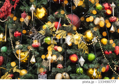 Details decorated Christmas tree with red, golden baubles and garland. Xmas card and pattern. Close up. Winter. Outdoor. 133490777