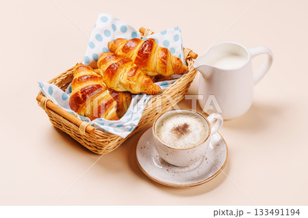 Aromatic croissants in wicker basket with cup of coffee 133491194