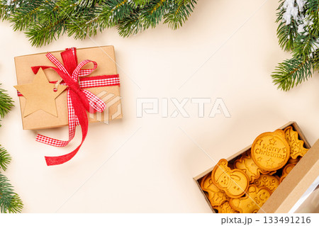 Gingerbread cookies, gift box and snowy fir branches 133491216