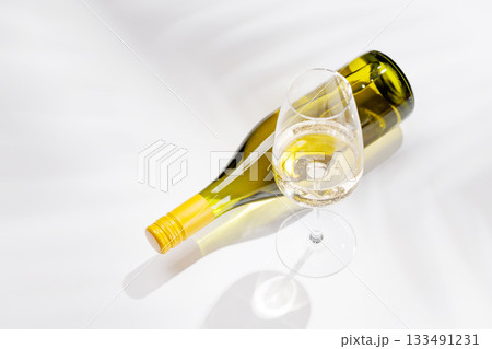 White wine bottle and glass on white background 133491231