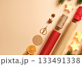 Items for gift wrapping with wrapping paper, rope, dried oranges, spices on beige background. Place for text or design. 133491338