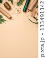 Gift wrapping background. Paper rolls, twine, gift tag, and gold stars on beige table. Copy space for holiday text or design. 133491342