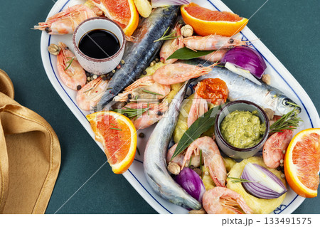 Plate with raw marinated seafood. 133491575