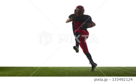 American football player jumping forward with intense determined emotion on field isolated on white background 133492124
