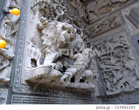 An Intricate Stone Carving of a Lion in Battle Amidst Detailed Relief Sculptures 133492285