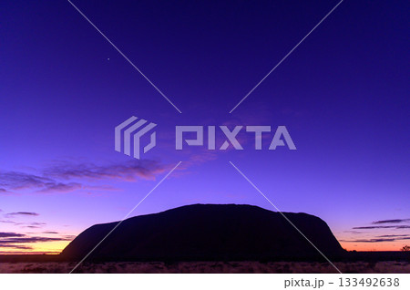 日の出間際の夜空に浮かぶエアーズロックのとても美しい風景 133492638
