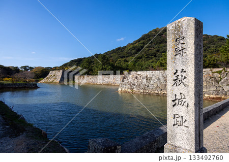 水堀と石垣に囲まれた萩城跡の美しい森と史跡の石標 133492760