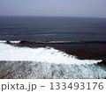 Ocean Waves Crashing Against a Cliffside with a Vast View of the Sea Under a Clear Sky 133493176