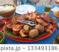 A Beachside Seafood Feast with Grilled Lobster, Crab, and Clams on a Red Platter with Rice and Beer 133493186