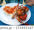 A Plate of Grilled Seafood with Rice and Spicy Sauce on a Beachside Dining Table 133493187