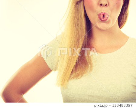 Funny blonde woman sitcking tongue out 133493387