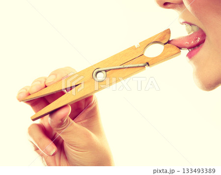 Blonde woman having tongue in clothespin Blonde woman having tongue in clothespin 133493389