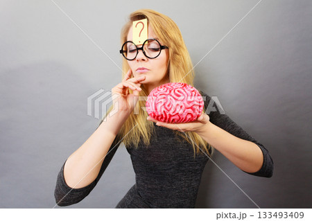 Weird woman holding brain having idea Weird woman holding brain having idea 133493409