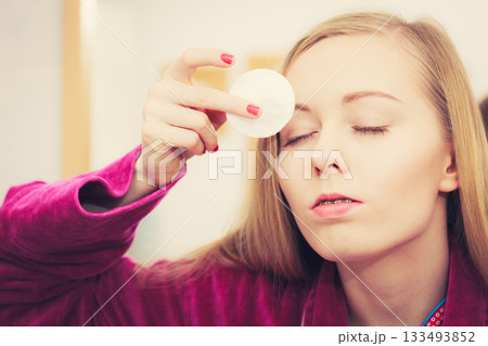 Woman using cotton pad to remove make up Woman using cotton pad to remove make up 133493852