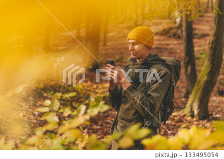 Man Hiker Using Smartphone for Navigation in Forest 133495054