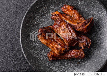 Grilled beef or pork ribs, meat cooked on a barbecue with salt and pepper. Grilled ribs Grilled beef or pork ribs, meat cooked on a barbecue with salt and pepper. Grilled ribs 133496115