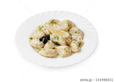 Homemade dumplings served with herbs and olives on a white plate Homemade dumplings served with herbs and olives on a white plate 133496831