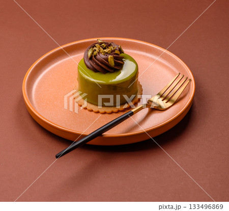 Pistachio cake or tart topped with green mousse with nuts and fruit filling. Pistachio pie 133496869