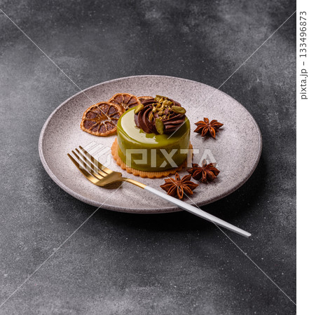 Pistachio cake or tart topped with green mousse with nuts and fruit filling. Pistachio pie 133496873