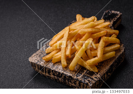 Crispy French fries with sauce, fast food, snack or chips. French fries, takeaway food Crispy French fries with sauce, fast food, snack or chips. French fries, takeaway food 133497033