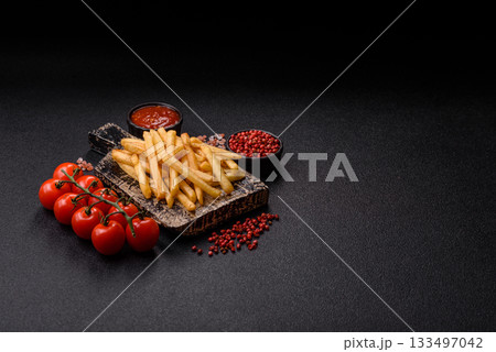 Crispy French fries with sauce, fast food, snack or chips. French fries, takeaway food 133497042