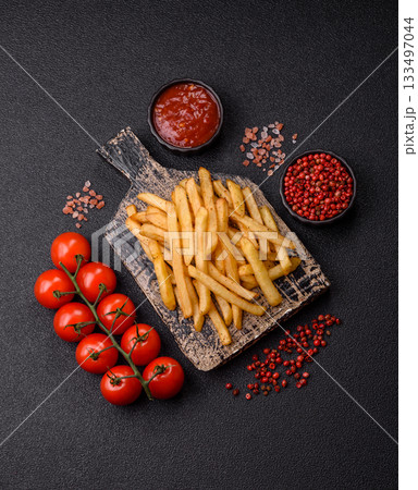 Crispy French fries with sauce, fast food, snack or chips. French fries, takeaway food 133497044