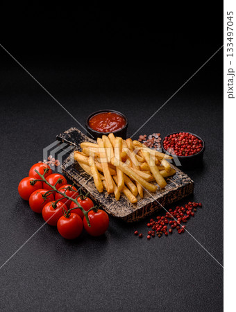 Crispy French fries with sauce, fast food, snack or chips. French fries, takeaway food Crispy French fries with sauce, fast food, snack or chips. French fries, takeaway food 133497045