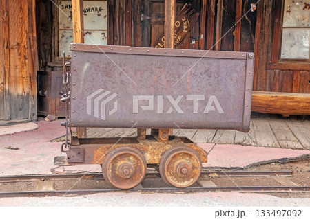 Rusty Mining Ore Cart on Rails in Old Western Town 133497092
