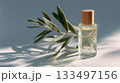 Natural oil with wooden cap and olive branch on sunlit surface 133497156